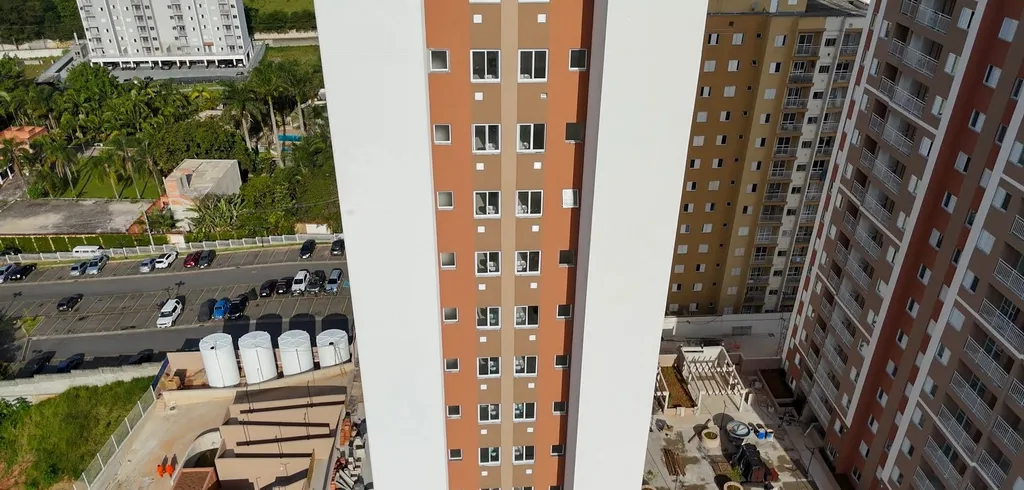 A torre do Residencial CDHU em Ferraz de Vasconcelos, em alvenaria, vista de baixo, com a grua ao lado