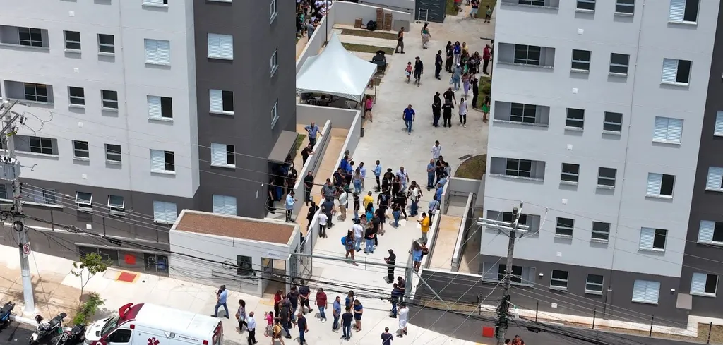 Vista aérea dos dois blocos entregues do Residencial Casa Nova, com moradores no pátio entre eles
